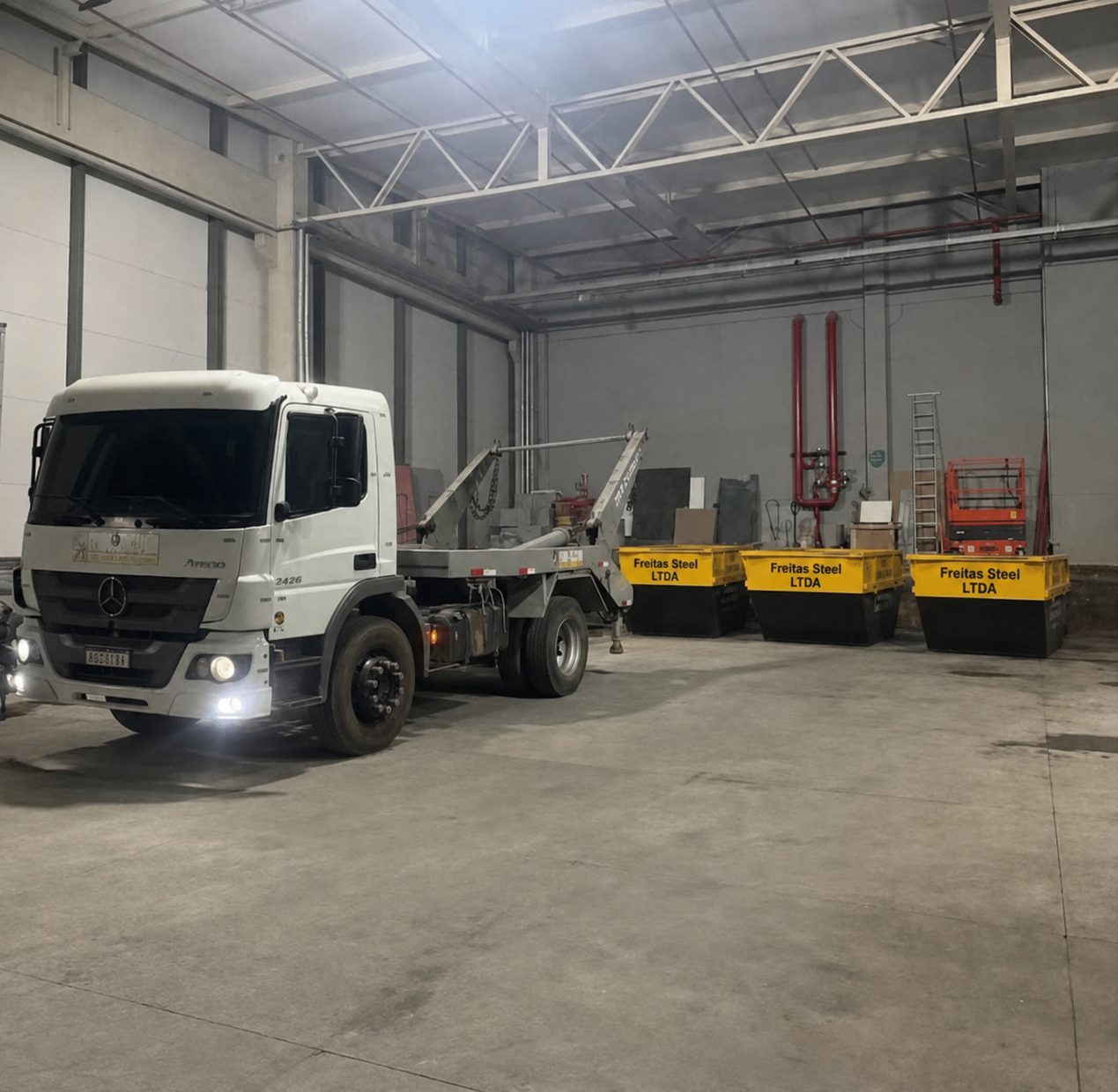 Galpão da Freitas Steel com caminhão e caçambas